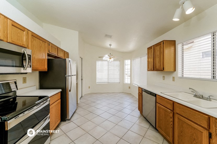 an empty kitchen with a stove refrigerator and sink