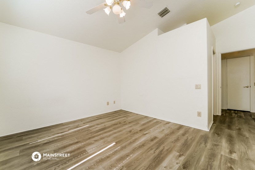 a empty room with white walls and wood flooring
