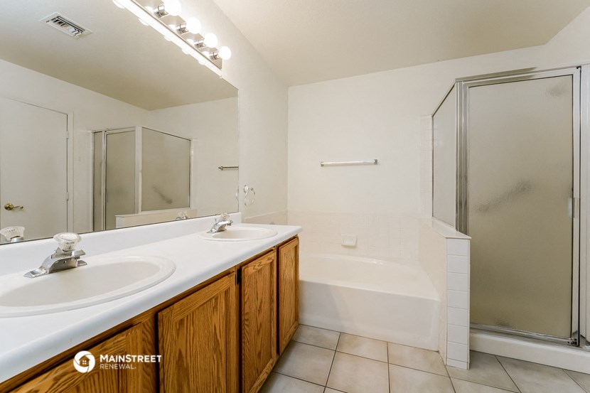 a bathroom with two sinks and a tub and a shower