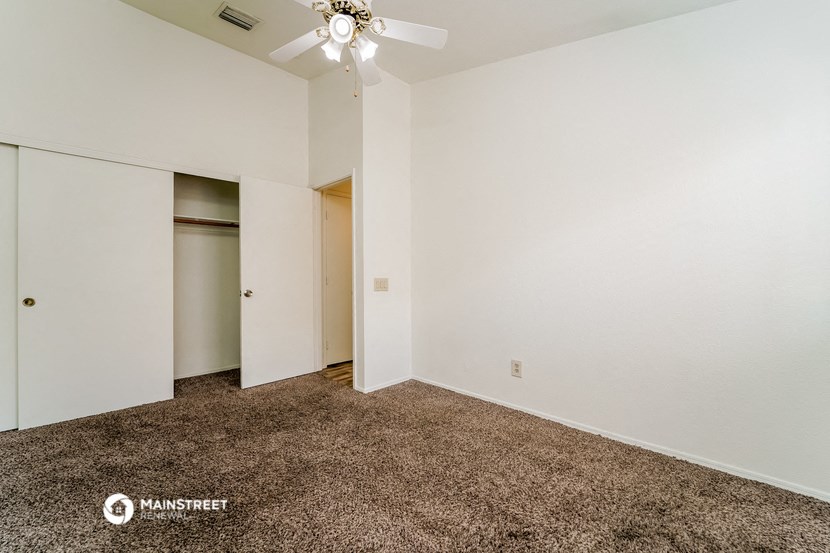 an empty room with a ceiling fan and a closet
