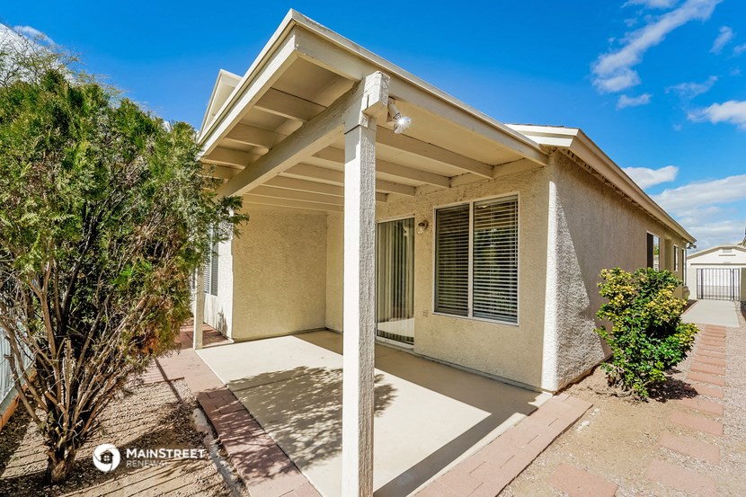 a small house with a porch and a tree