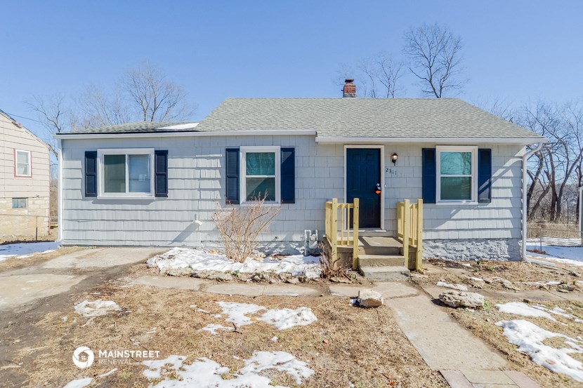 a small white house with blue doors and a porch