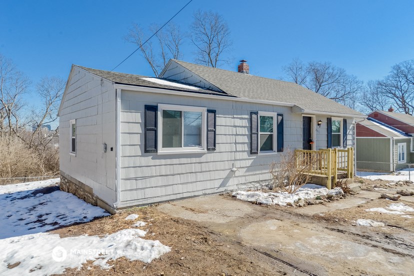 a small white house with a yard in the snow