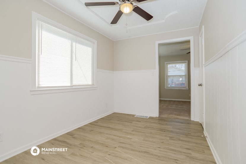 the living room of an empty house with a ceiling fan
