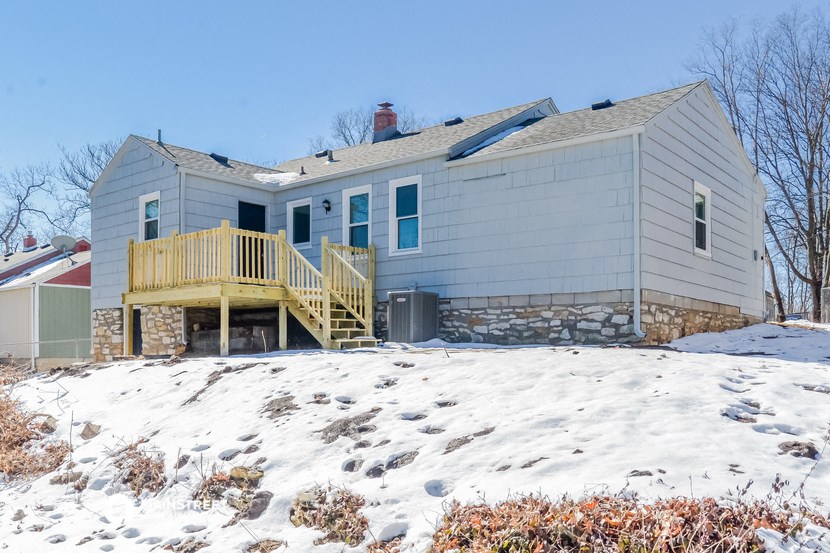 a white house with a deck in the snow
