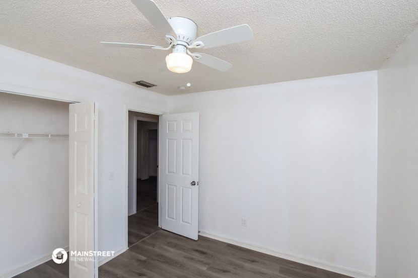 a bedroom with a ceiling fan and a closet
