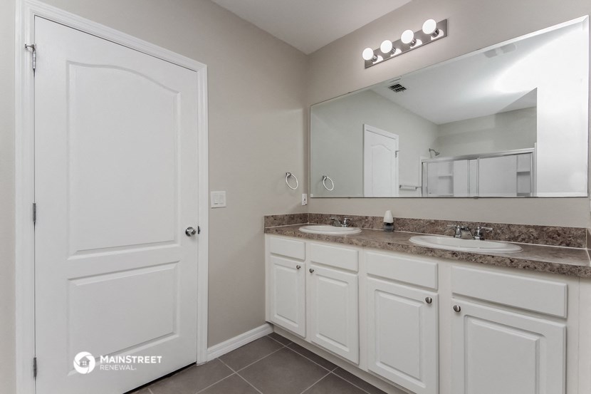 a bathroom with two sinks and a large mirror