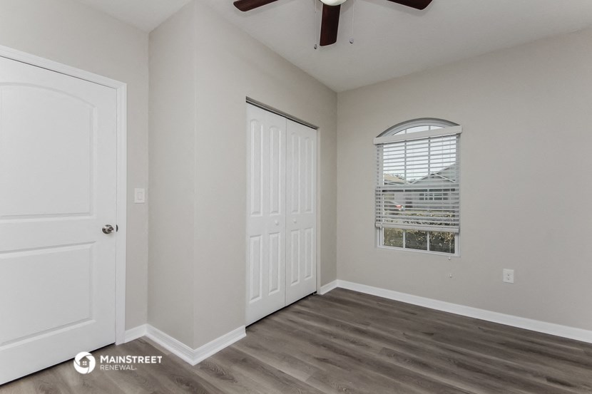 the living room of an apartment with a door and a window
