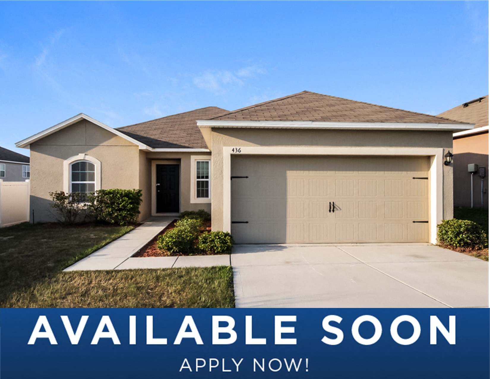 a beige house with a driveway and a garage door