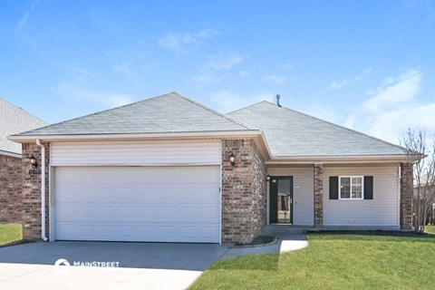 a brick house with a white garage door and a lawn