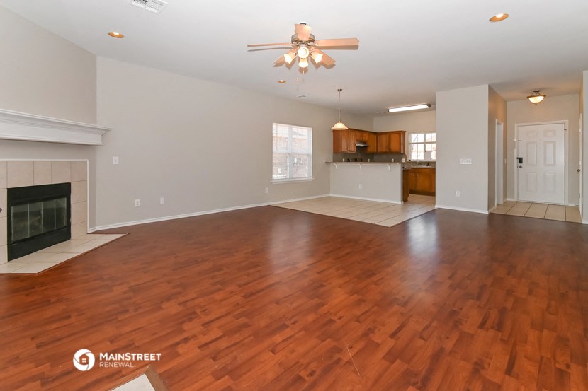 an empty living room with wood flooring and a fireplace