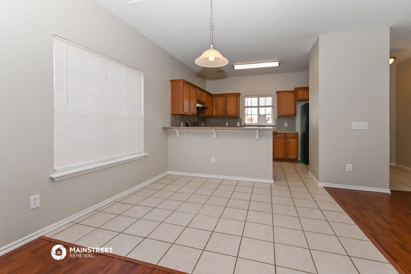 an empty kitchen and living room with a white tile floor