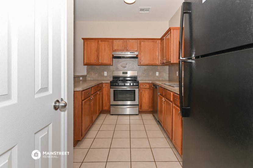 a kitchen with wooden cabinets and stainless steel appliances
