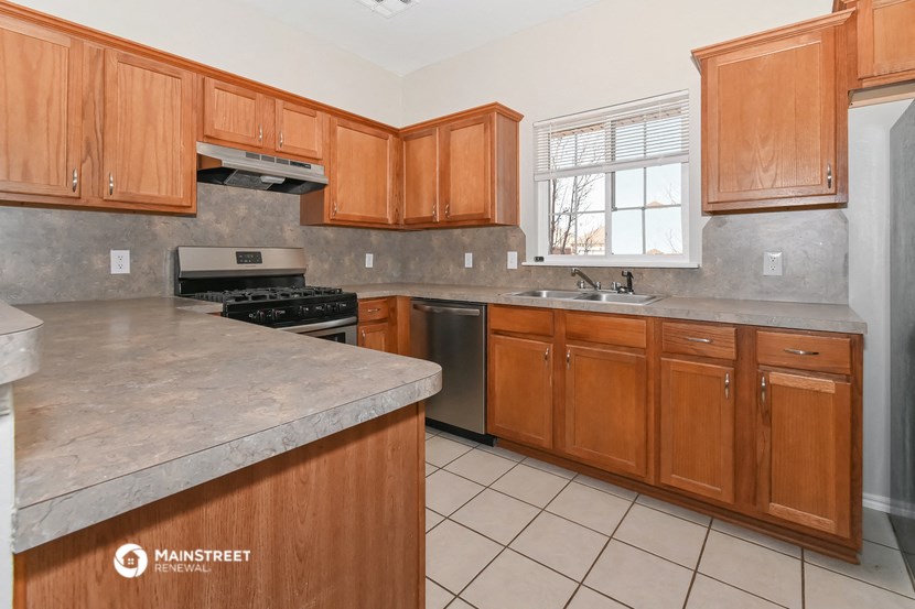 a kitchen with wooden cabinets and marble counter tops