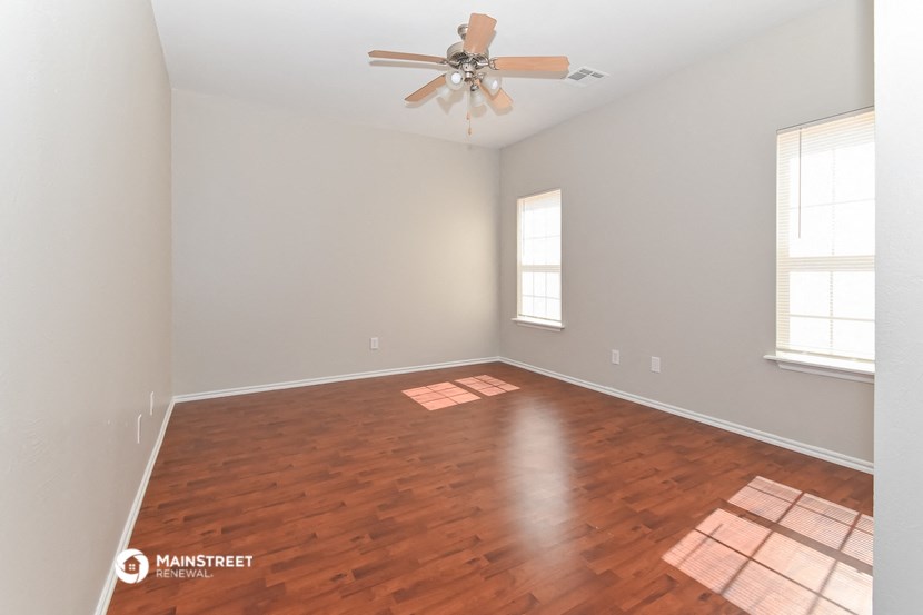 the living room with hardwood floors and a ceiling fan