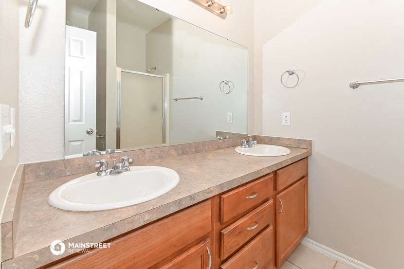 a bathroom with two sinks and a large mirror