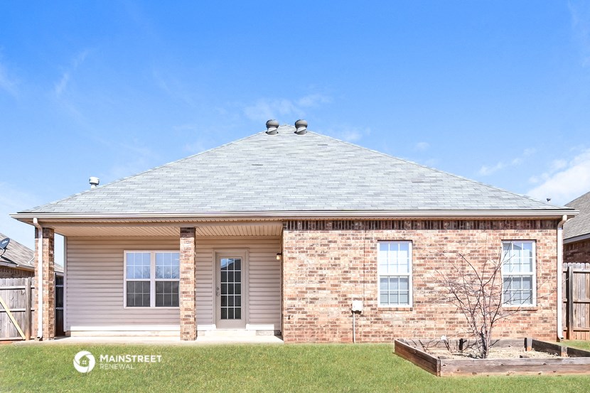 a brick house with a gray roof on a lawn