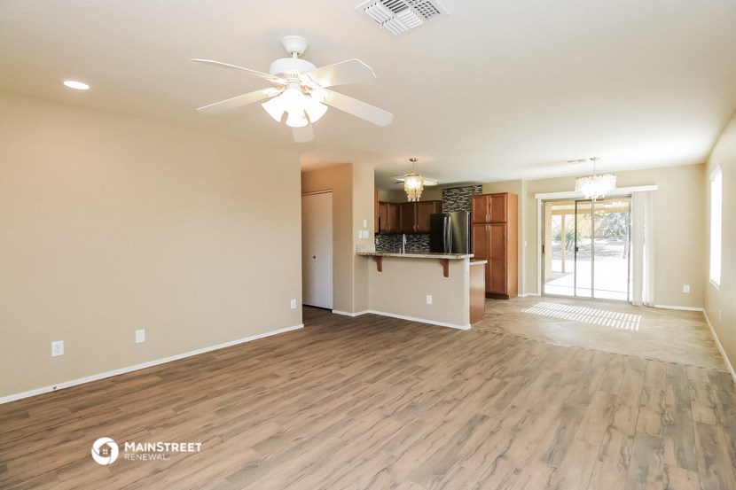 an open living room and kitchen with a ceiling fan