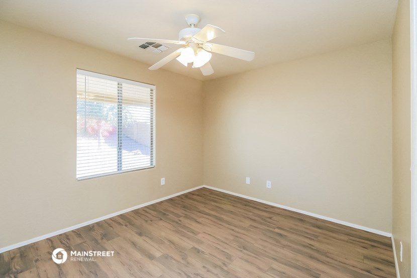 an empty room with a ceiling fan and a window