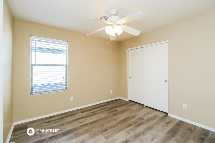 an empty room with a ceiling fan and a window