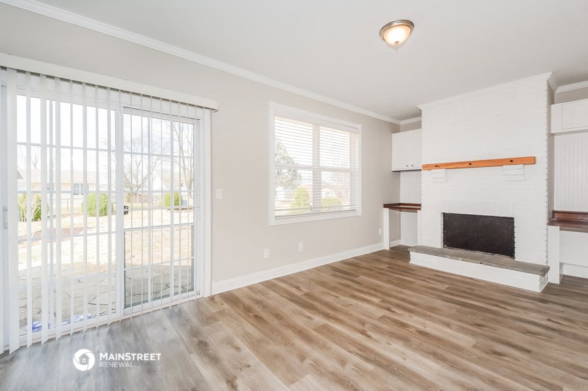 a living room with a fireplace and a sliding glass door