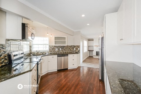 a kitchen with white cabinets and stainless steel appliances