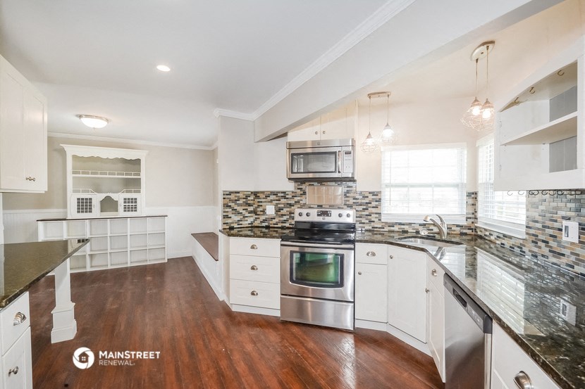 a kitchen with white cabinets and stainless steel appliances