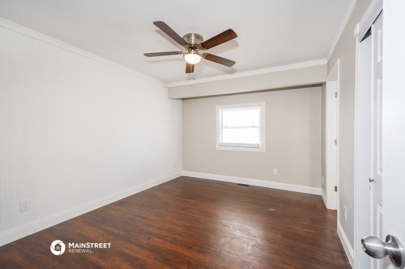 the living room of an empty house with a ceiling fan