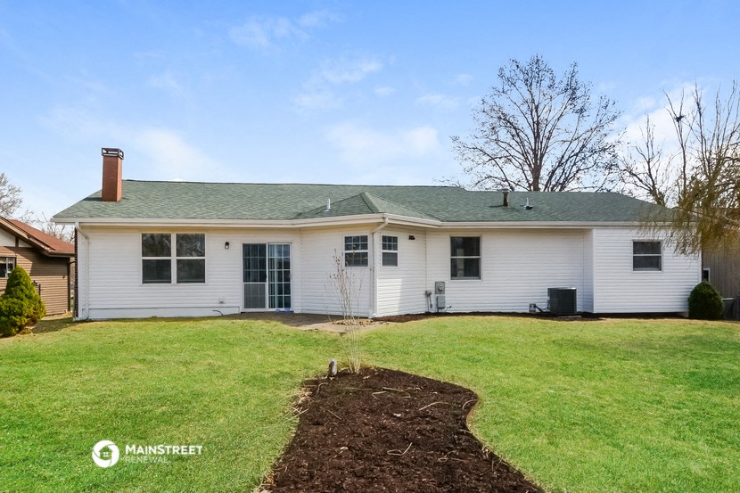 the front of a white house with a green lawn