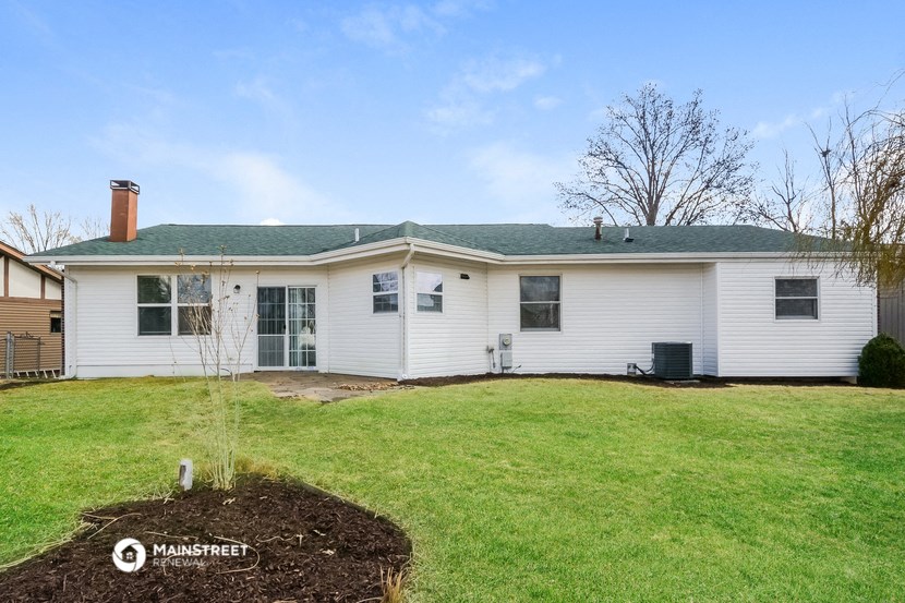 a white house with a green lawn and a green roof