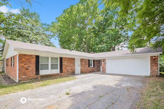 a brick house with a large driveway and a white garage door