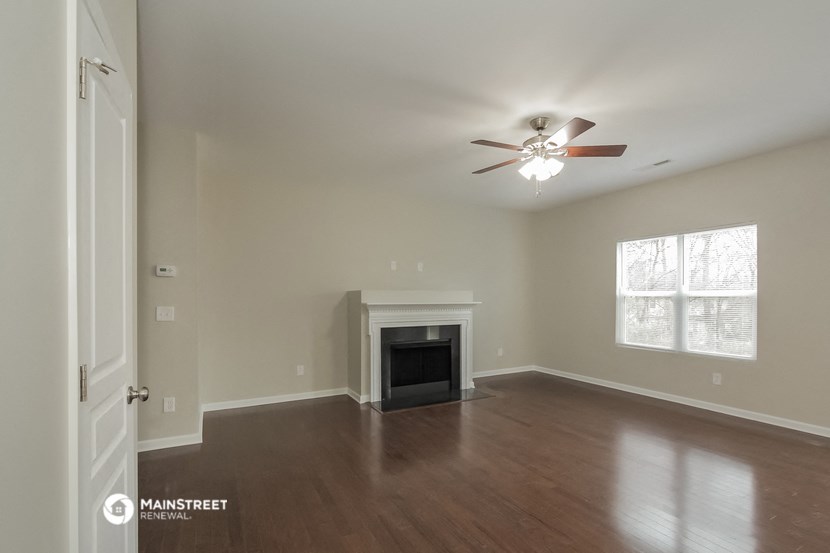 the living room with fireplace and ceiling fan