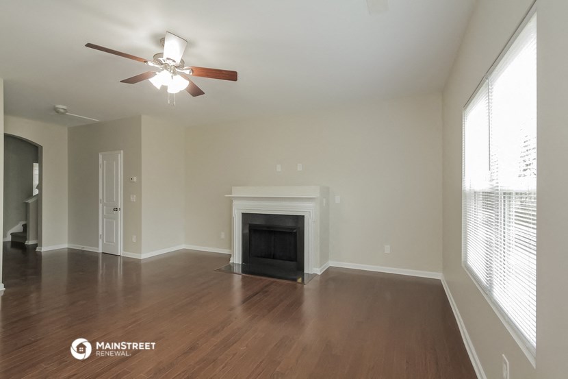 the living room with fireplace and ceiling fan
