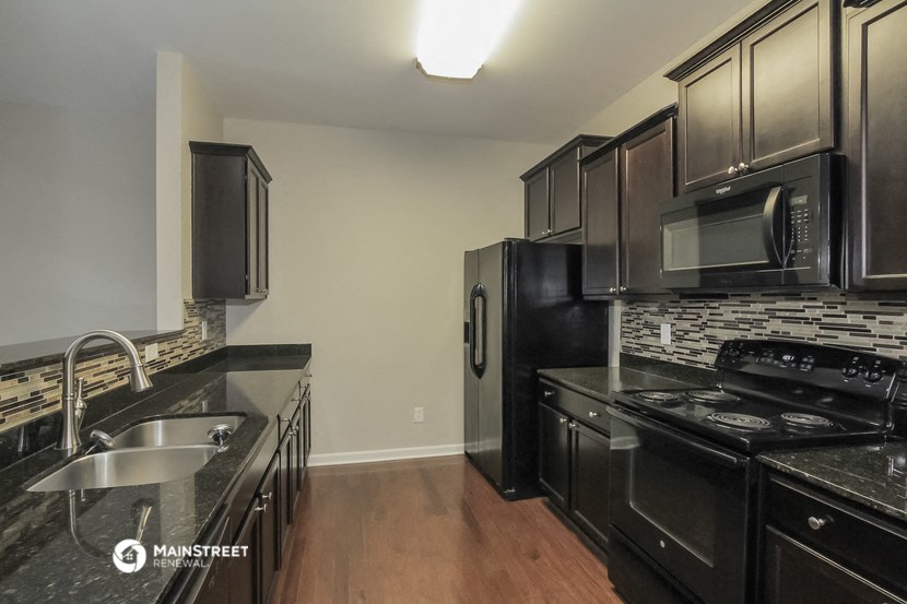 a kitchen with black appliances and stainless steel appliances and black cabinets