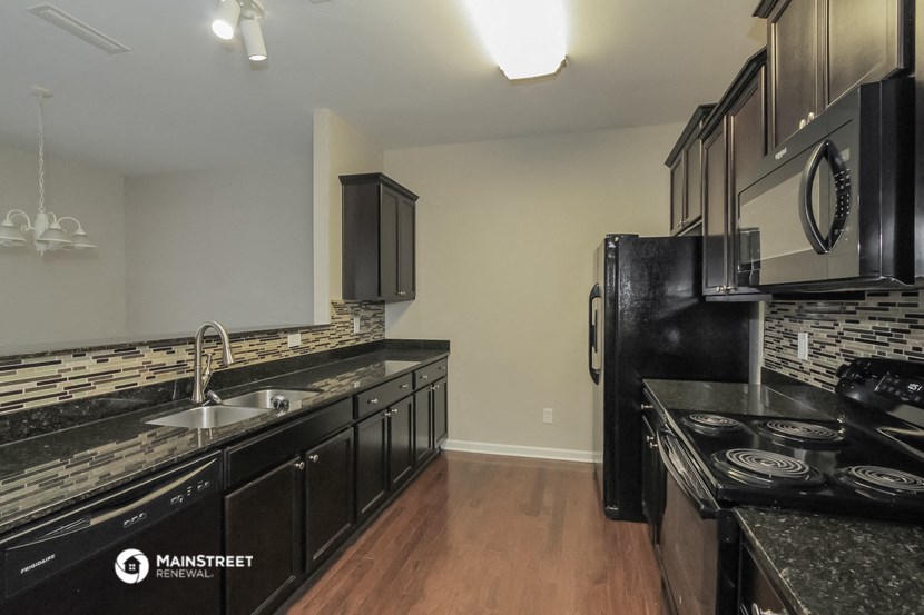 a kitchen with black cabinets and black appliances and a black refrigerator