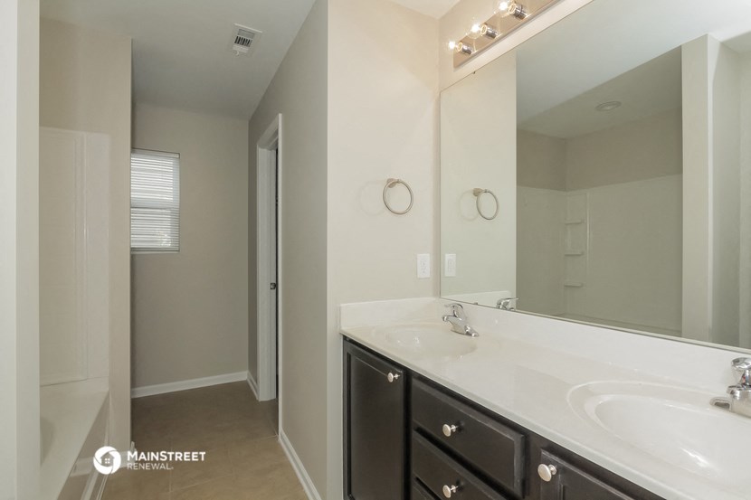 a bathroom with a sink and a mirror and a shower
