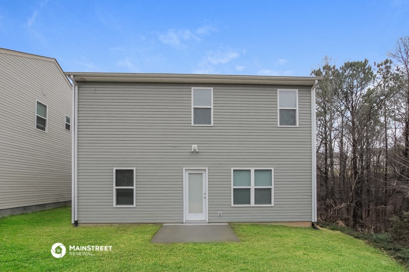 the exterior of a home with a gray siding exterior and a green lawn