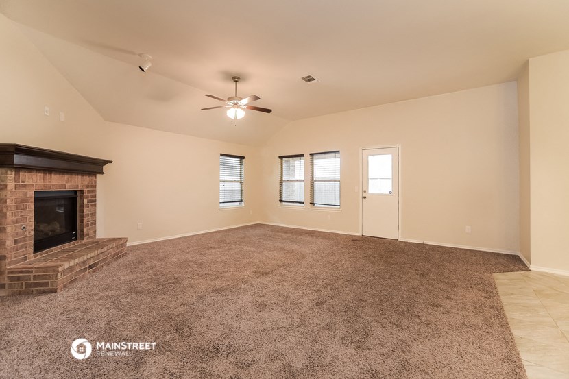 the living room has a fireplace and carpeted flooring