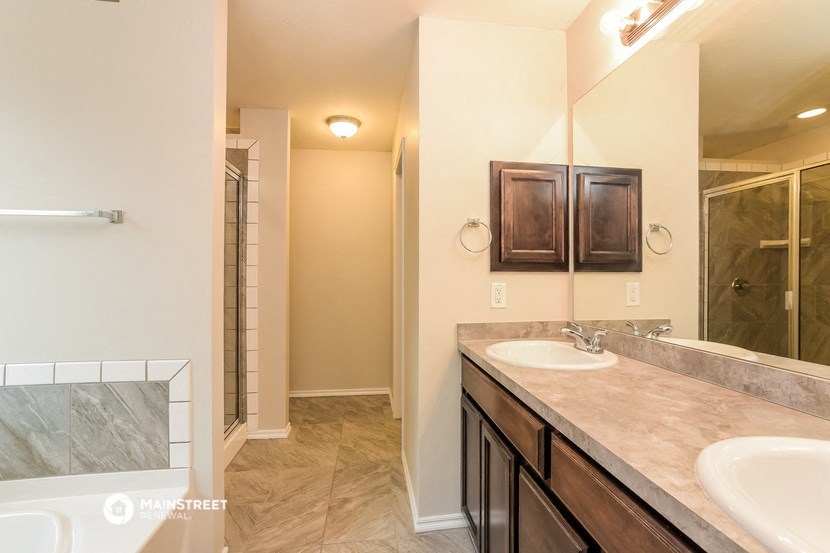the master bathroom has dual sinks and a large shower