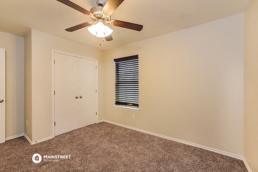 the upstairs bedroom has a ceiling fan and a closet