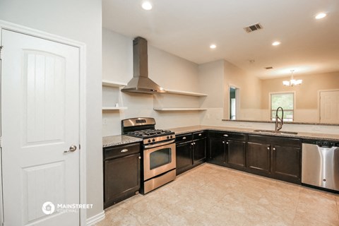 a kitchen with black cabinets and stainless steel appliances