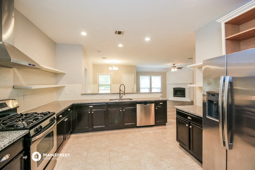 a large kitchen with black cabinets and stainless steel appliances