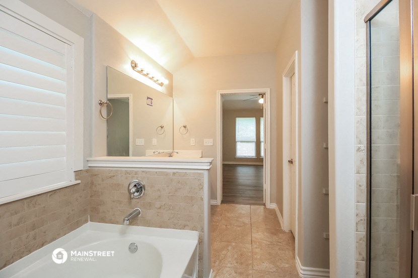 a bathroom with a tub and a sink and a mirror