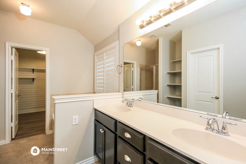 a bathroom with two sinks and a large mirror