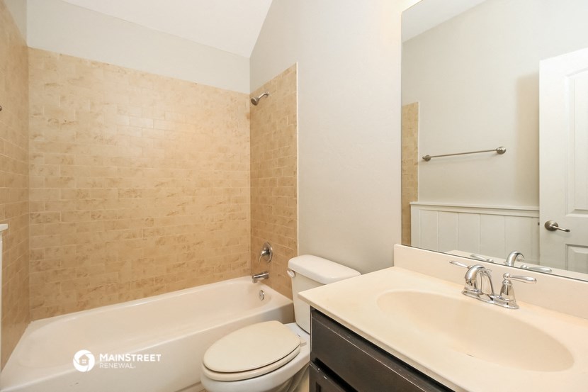 a bathroom with a sink toilet and bath tub and a mirror