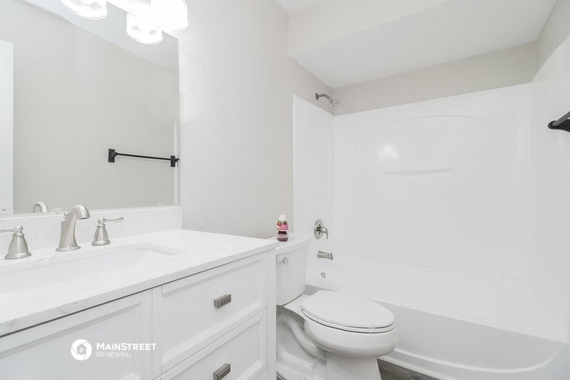 a white bathroom with a white toilet and a sink