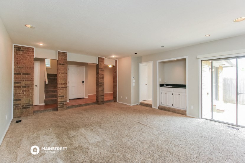 a living room with a carpeted floor and a large window