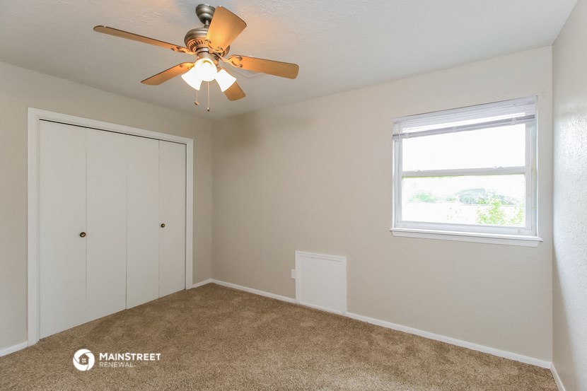 a bedroom with a ceiling fan and a closet