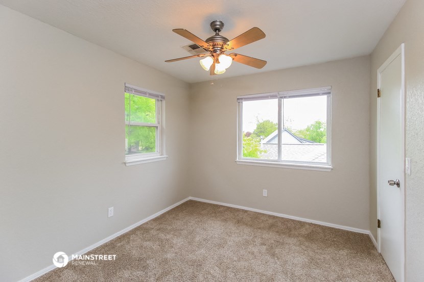 the master bedroom is spacious and has a ceiling fan and two windows