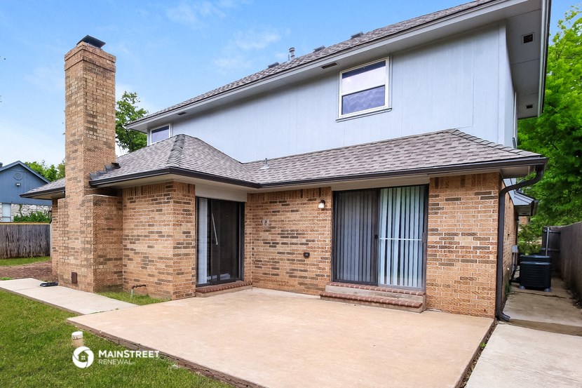 the front of a house with a patio and a driveway